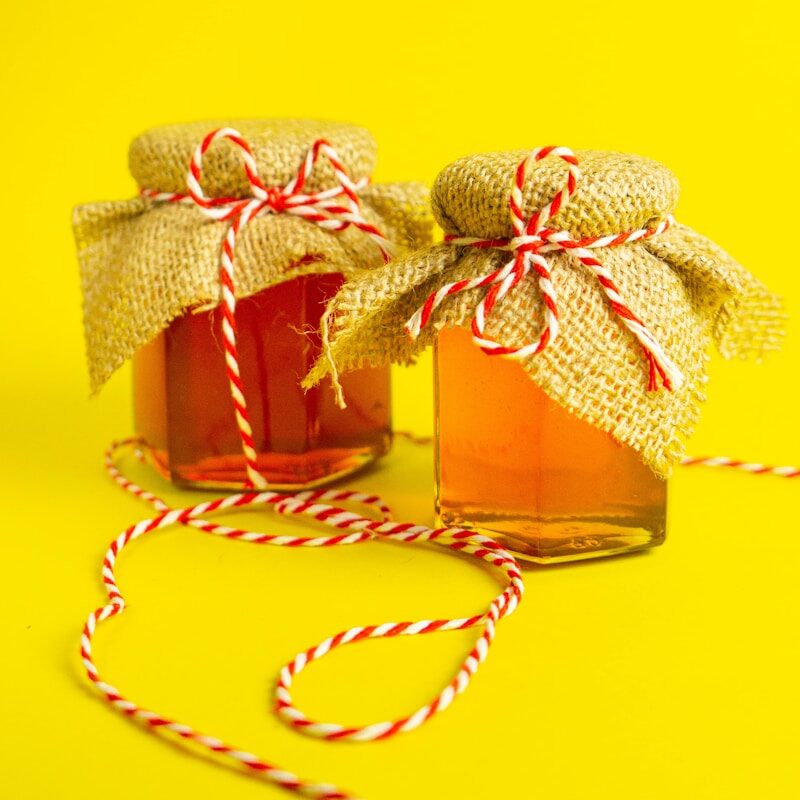 two jars of honey tied with twine and twine of twine